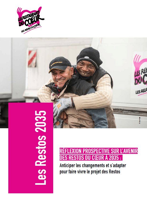 Deux hommes souriants s'enlacent face à la caméra devant un camion des restos du coeur
